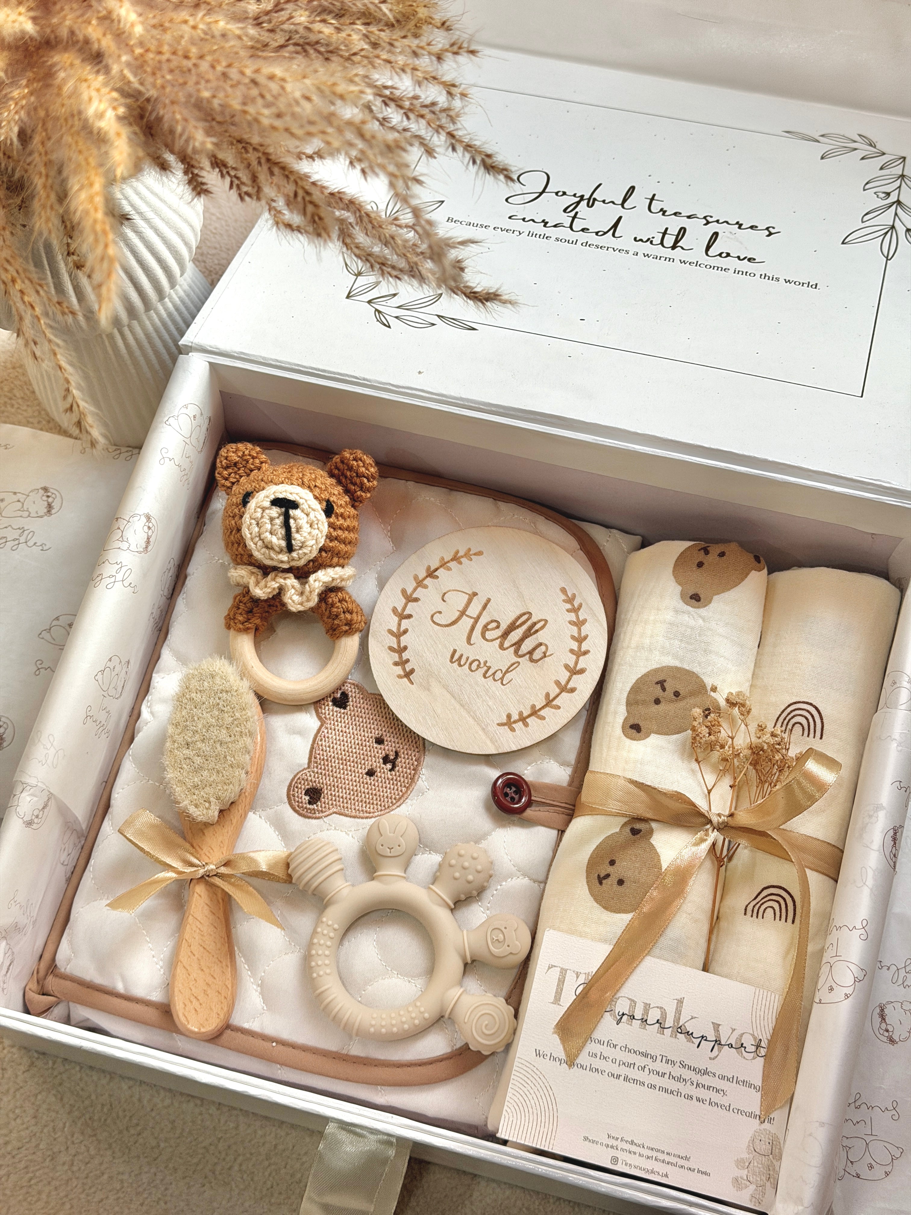 Baby gift set with wooden toys and items in a decorative box.