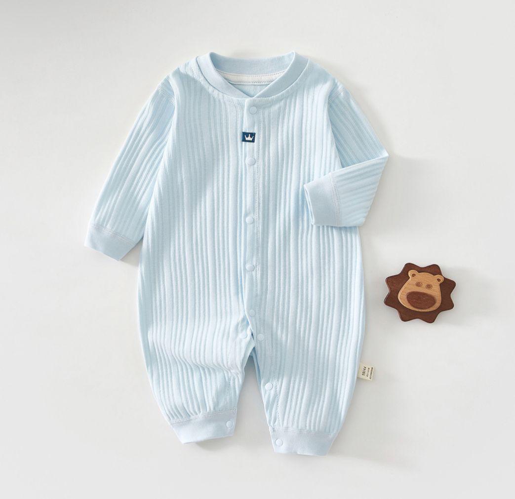 Baby blue ribbed onesie on a white background with a wooden toy lion.