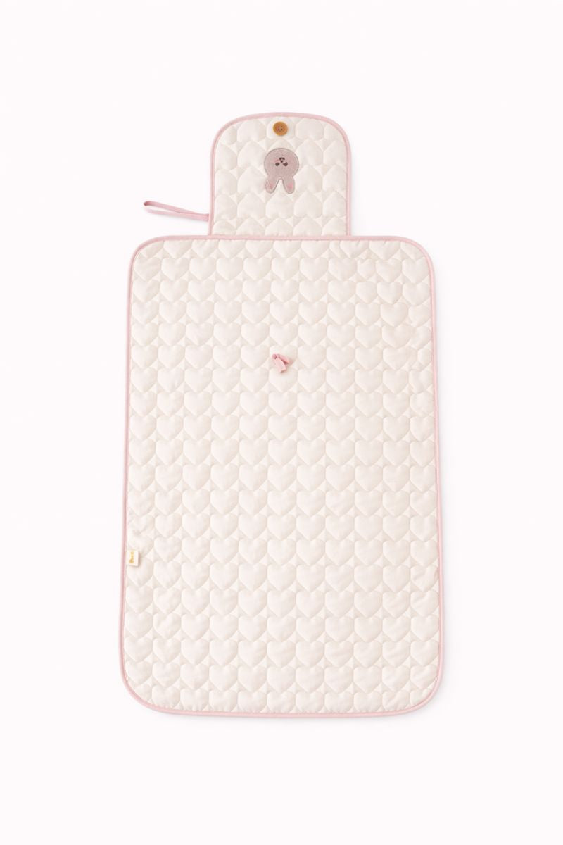 An opened, laid out flat, light pink, bunny themed diaper changing pad
