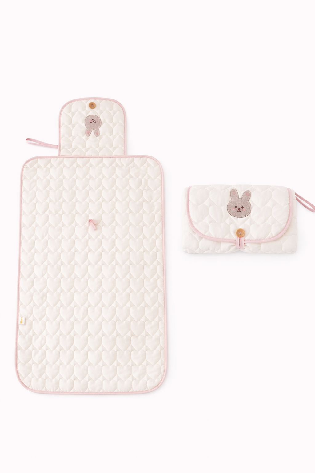 A bunny themed light pink colored diaper changing pad for babies