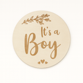 Round wooden sign with 'It's a Boy' text on a white background