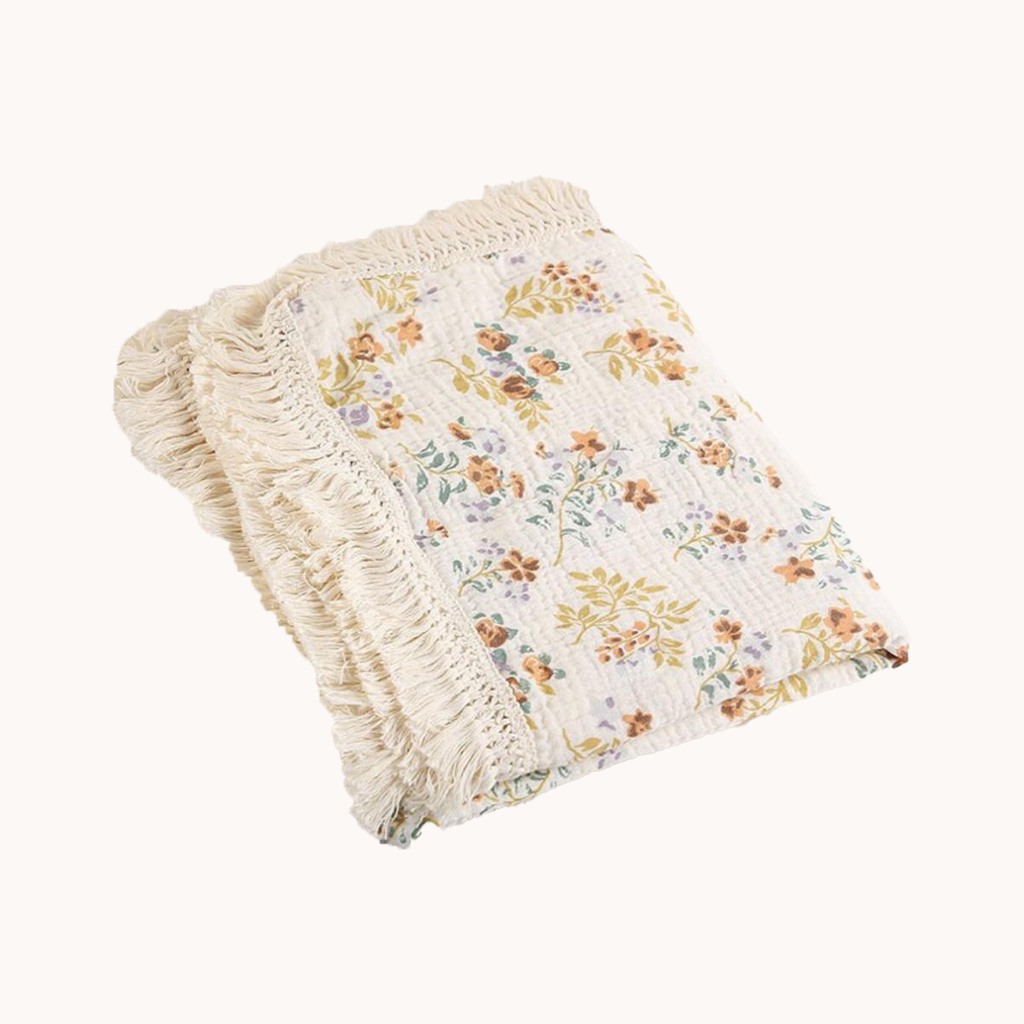 Floral patterned blanket with frayed edges on a white background